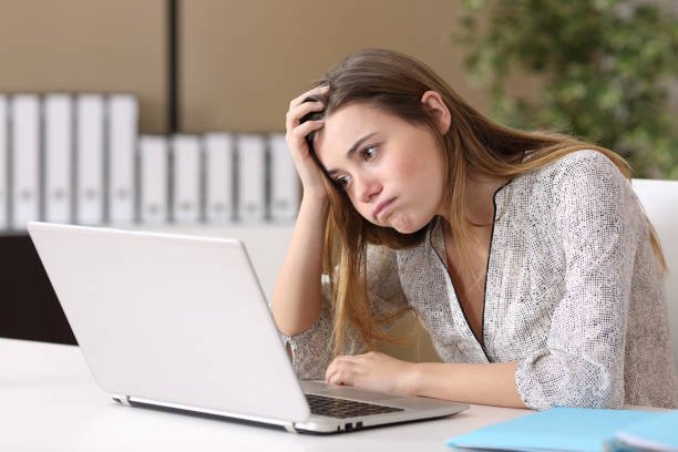 image of unhappy woman staring at a computer screen